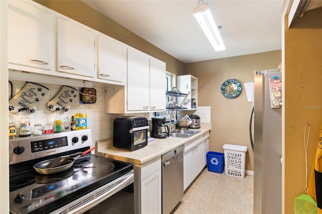 kitchen with white cabinets, backsplash, sink, and appliances with stainless steel finishes