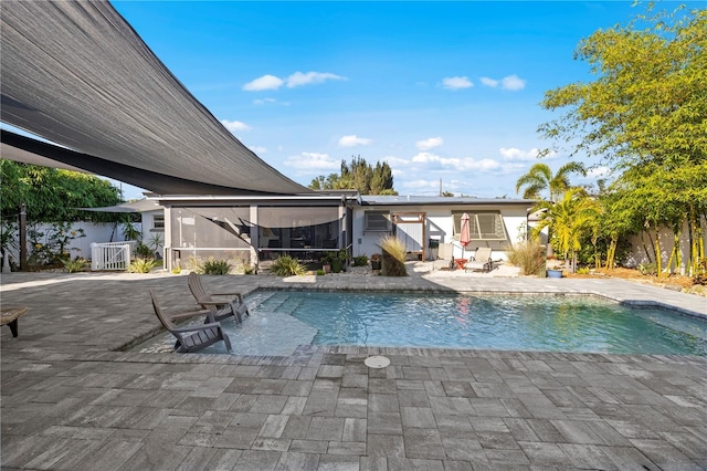 view of pool with a sunroom and a patio