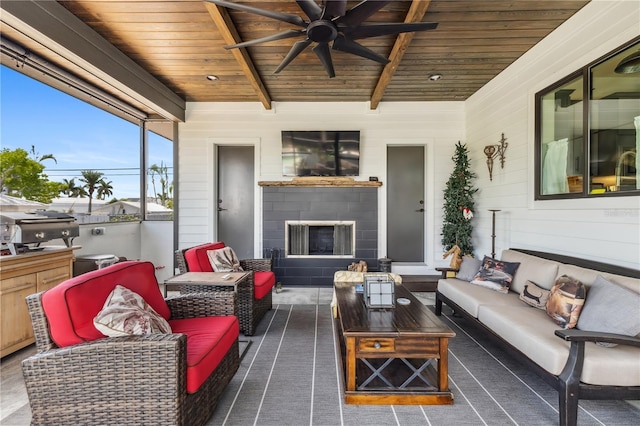 sunroom with beam ceiling, ceiling fan, wooden ceiling, and exterior fireplace