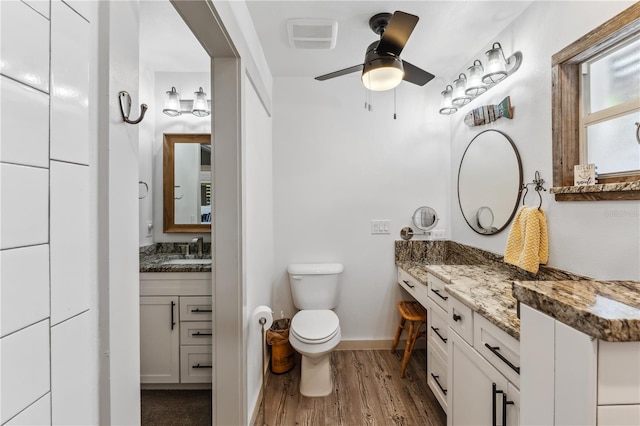 bathroom featuring ceiling fan, hardwood / wood-style floors, vanity, and toilet