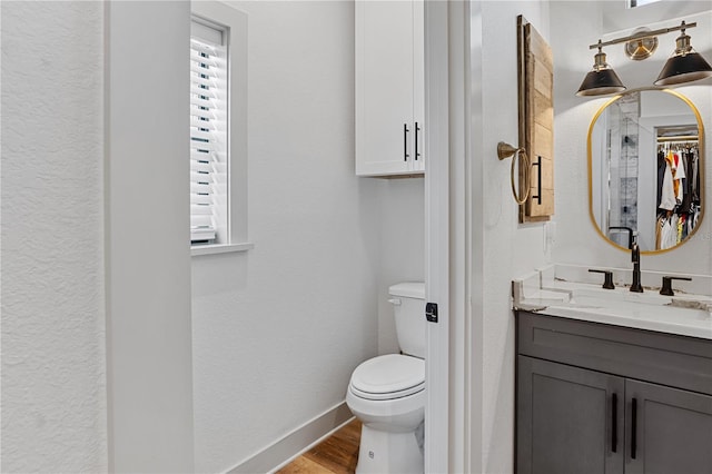 bathroom featuring vanity, hardwood / wood-style flooring, toilet, and a wealth of natural light