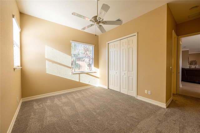 unfurnished bedroom featuring carpet flooring, ceiling fan, and a closet