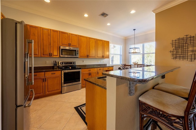 kitchen featuring a breakfast bar area, light tile patterned flooring, hanging light fixtures, and appliances with stainless steel finishes