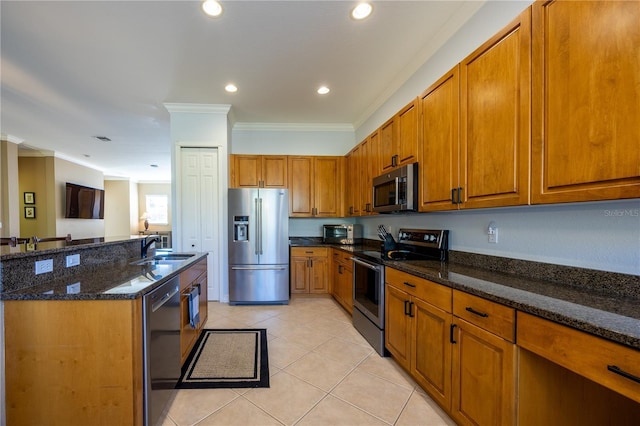 kitchen featuring sink, dark stone countertops, ornamental molding, light tile patterned floors, and stainless steel appliances