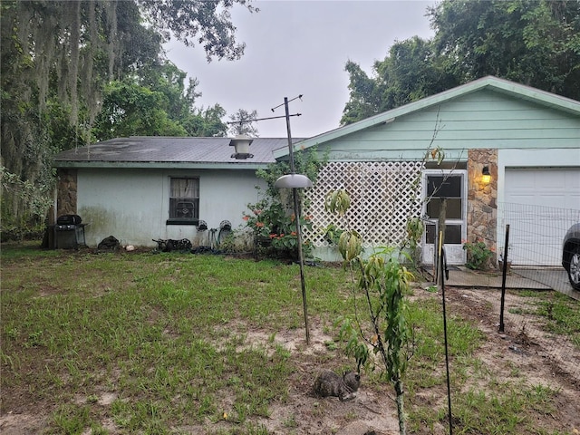 rear view of property with a lawn and a garage