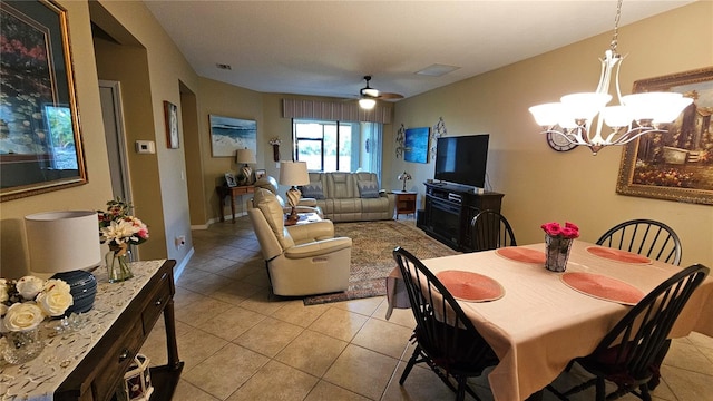 tiled dining room with ceiling fan with notable chandelier