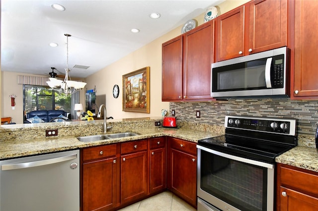 kitchen with backsplash, sink, a notable chandelier, light stone counters, and stainless steel appliances