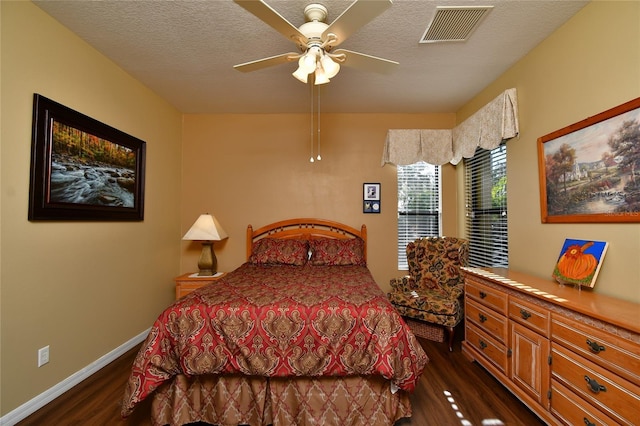 bedroom with a textured ceiling, dark hardwood / wood-style floors, and ceiling fan