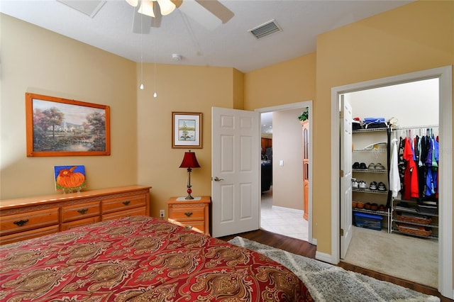 carpeted bedroom with ceiling fan, a spacious closet, and a closet