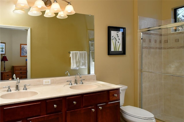 bathroom with vanity, a shower with shower door, and toilet