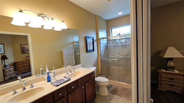 bathroom with toilet, vanity, tile patterned floors, and a shower with door