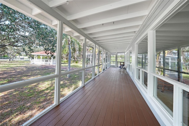 unfurnished sunroom featuring beam ceiling