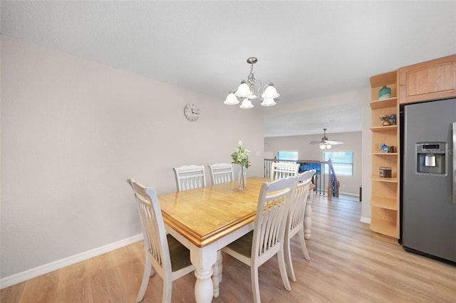 dining space featuring ceiling fan with notable chandelier and light hardwood / wood-style floors