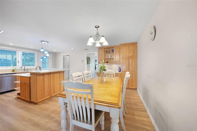 dining room featuring light hardwood / wood-style floors, sink, and a chandelier