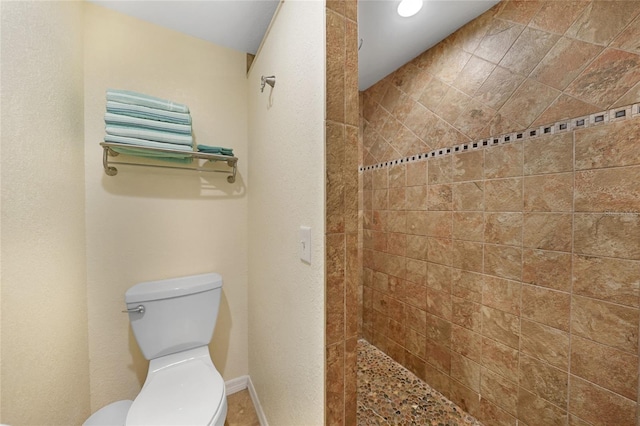 bathroom with tiled shower and toilet