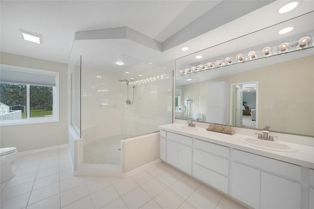 bathroom featuring toilet, tile patterned flooring, vanity, and tiled shower