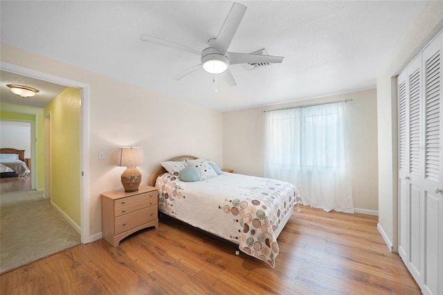 bedroom with a closet, light hardwood / wood-style flooring, and ceiling fan