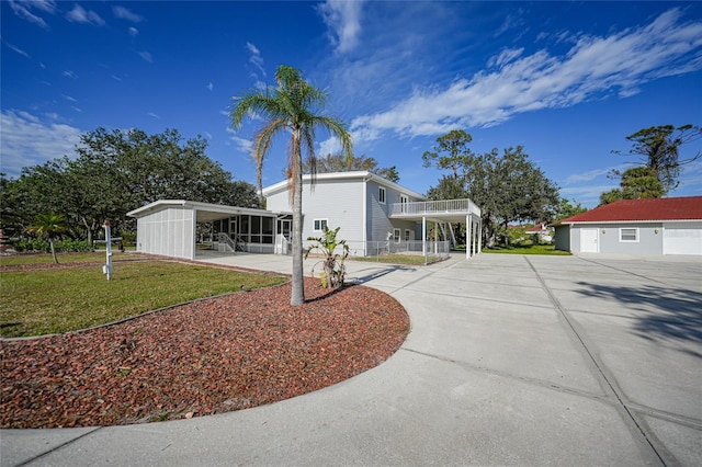 exterior space with a sunroom, a yard, and a carport