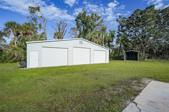 garage with a carport and a yard