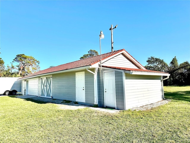 view of outbuilding with a lawn and a garage