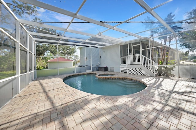 view of pool featuring an in ground hot tub, a patio, and a lanai