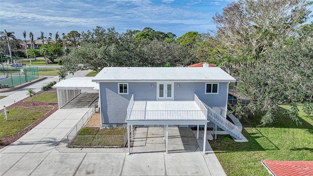 view of front of home with french doors, a front lawn, and a carport