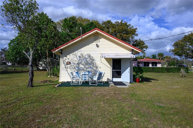 rear view of house featuring a lawn