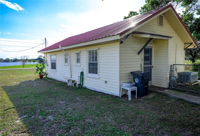 view of side of home featuring a yard and central AC