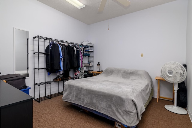 bedroom featuring ceiling fan, a textured ceiling, and dark colored carpet