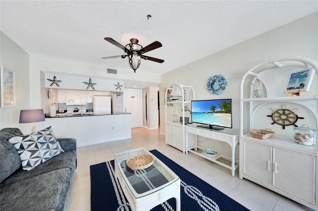 tiled living room featuring ceiling fan and a textured ceiling