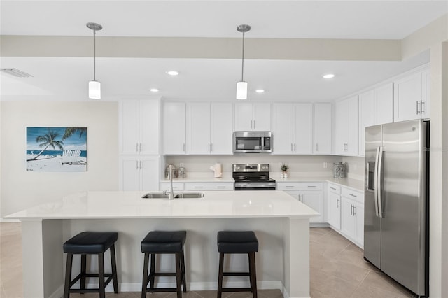 kitchen with sink, white cabinetry, stainless steel appliances, and a kitchen island with sink