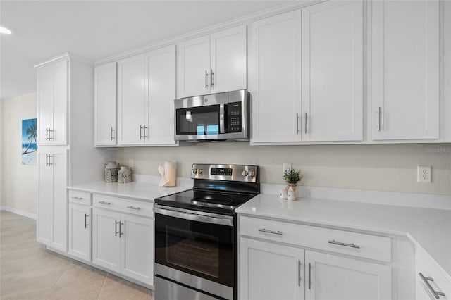 kitchen with light tile patterned floors, stainless steel appliances, and white cabinetry