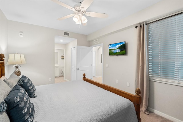 bedroom featuring ceiling fan, light colored carpet, and ensuite bathroom