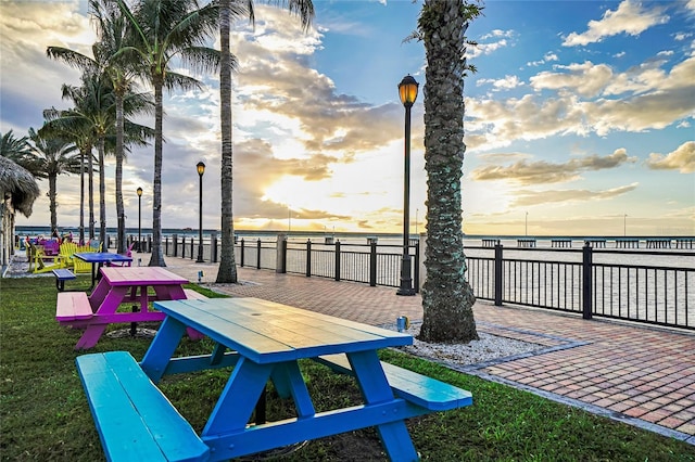 patio terrace at dusk featuring a water view