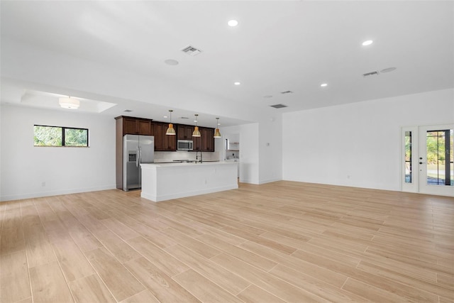 unfurnished living room featuring light hardwood / wood-style floors and sink