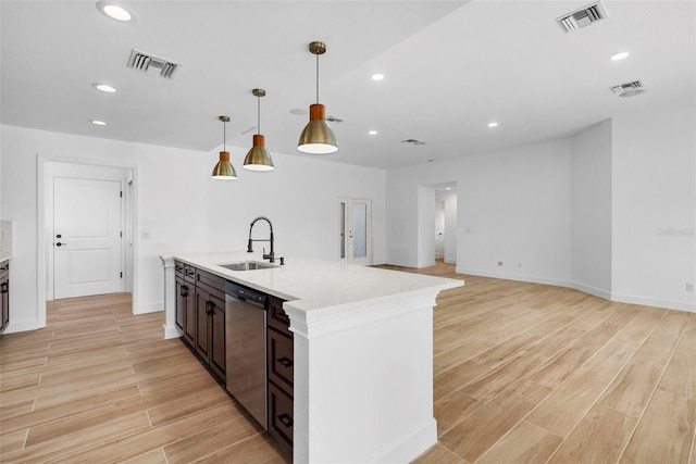 kitchen featuring pendant lighting, dishwasher, sink, dark brown cabinets, and light stone counters