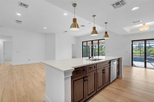 kitchen featuring stainless steel dishwasher, dark brown cabinetry, sink, pendant lighting, and light hardwood / wood-style floors