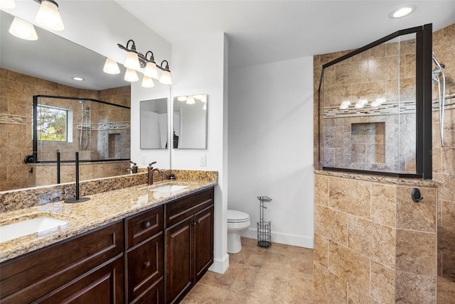 bathroom featuring vanity, toilet, and a shower with shower door