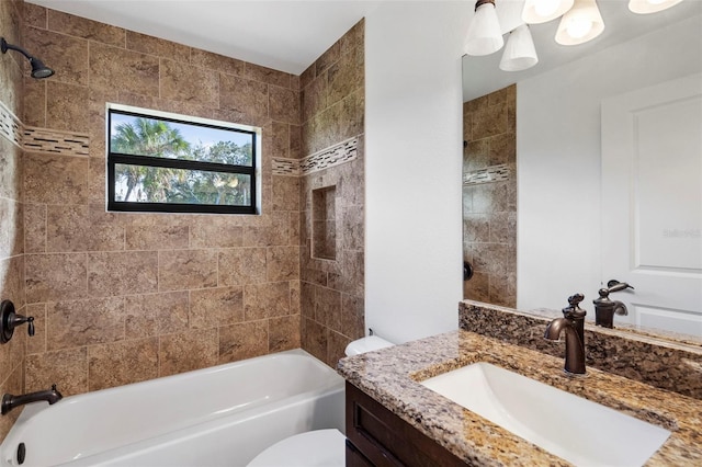 full bathroom with vanity, tiled shower / bath combo, and toilet