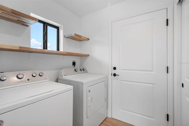 laundry area featuring washing machine and dryer and light wood-type flooring