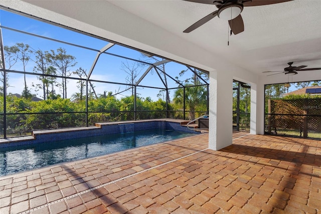 view of pool with a patio area, ceiling fan, and glass enclosure