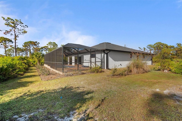 rear view of property with a lanai and a lawn