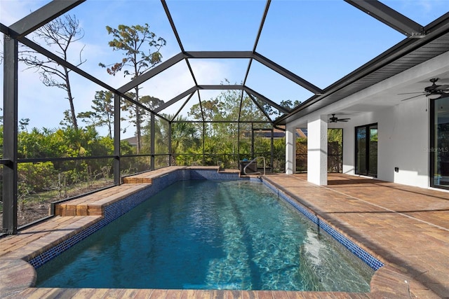 view of swimming pool featuring a patio area, ceiling fan, and glass enclosure