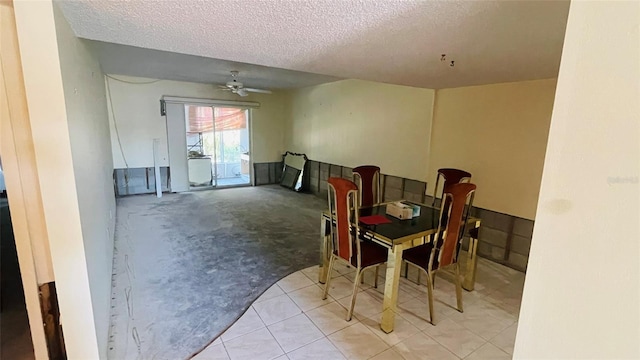 carpeted dining room with ceiling fan and a textured ceiling