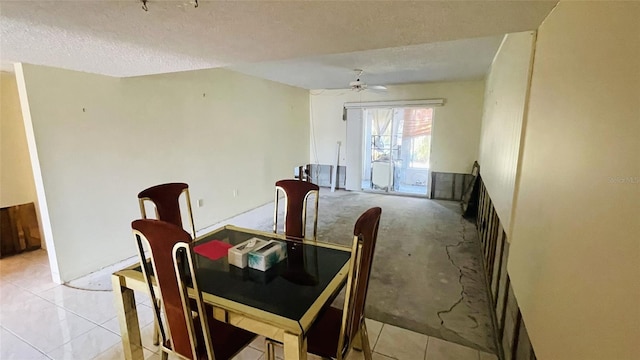 dining space featuring ceiling fan, light tile patterned flooring, and a textured ceiling