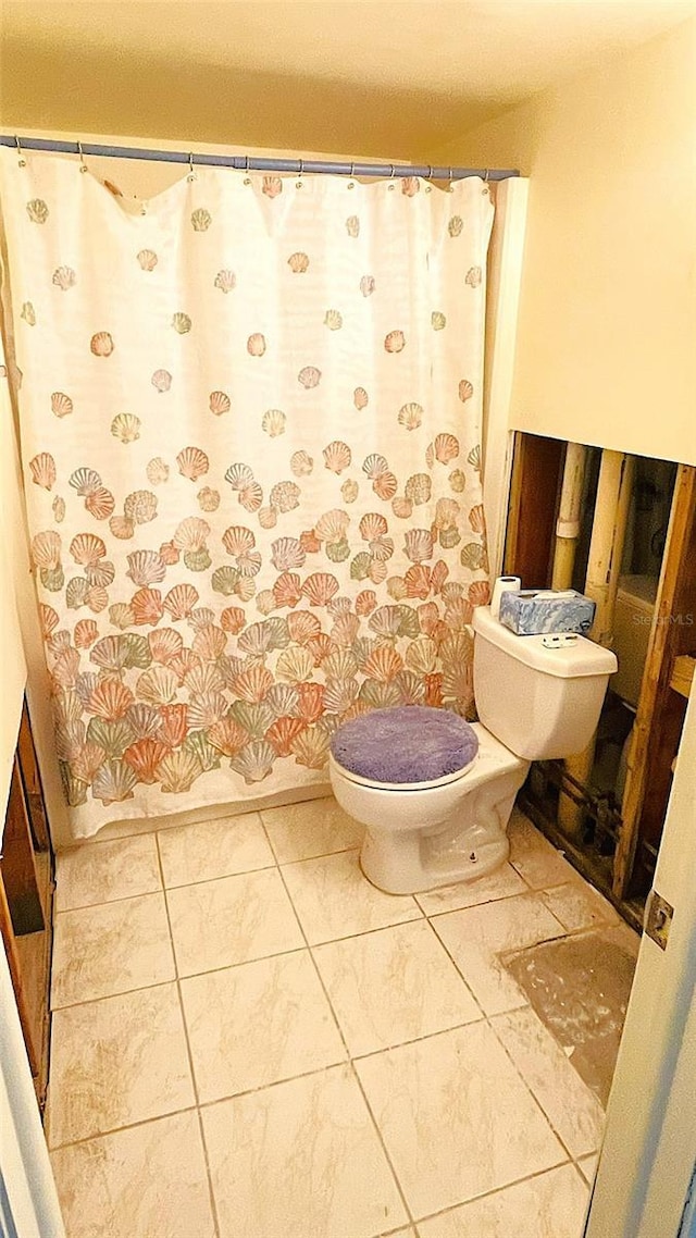 bathroom with tile patterned flooring and toilet