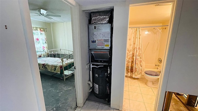 bathroom with tile patterned flooring, ceiling fan, toilet, and shower / tub combo