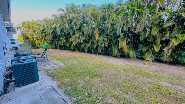 view of yard with central AC unit and a patio area