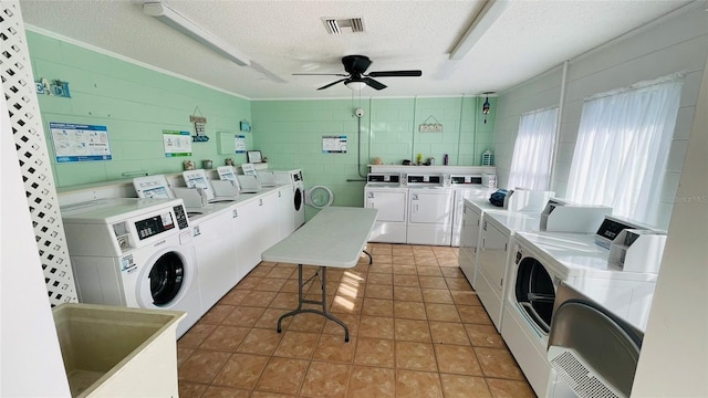 clothes washing area featuring tile patterned flooring, a textured ceiling, washing machine and dryer, and ceiling fan