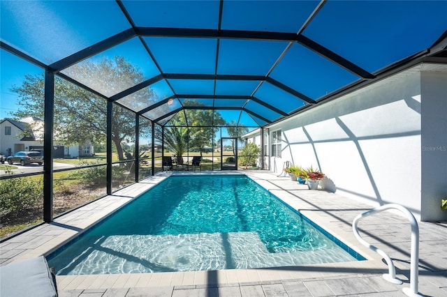 view of swimming pool with glass enclosure and a patio area